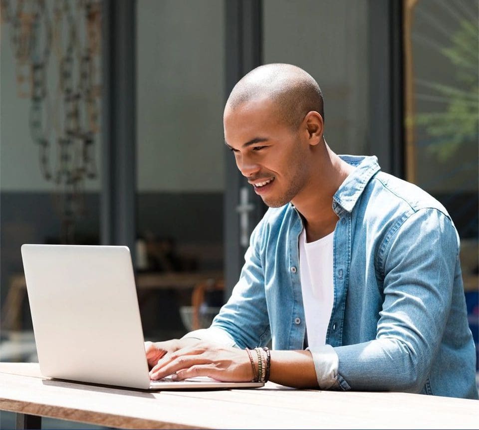 A man sitting at a table with a laptop.